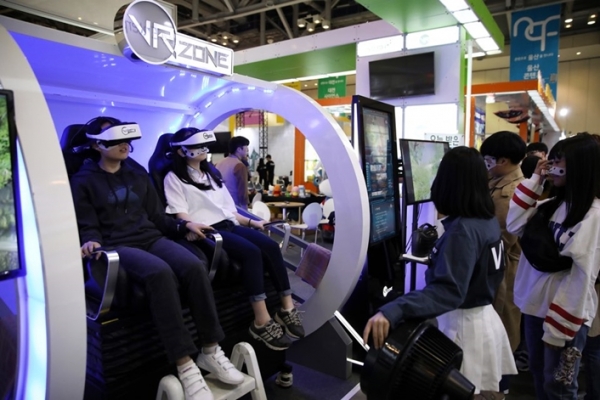 지난 4일 부산 벡스코에서 열린 '2018 넥스트 콘텐츠 페어'를 찾은 관람객들이 VR 콘텐츠를 체험하고 있다.
